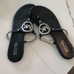 Michael Kors leather emblem sandals.